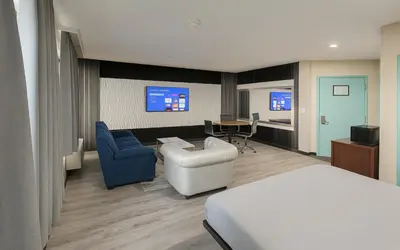 a hotel room with a bed and a living room at Hotel Pergola Jamaica JFK in Queens