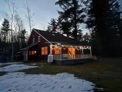 a house covered in christmas lights in the snow at Two Brooks Lodge in Bennington