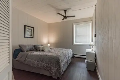 a bedroom with a bed and a ceiling fan at Two Brooks Lodge in Bennington