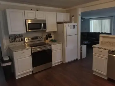 a kitchen with white cabinets and a stove and refrigerator at Two Brooks Lodge in Bennington