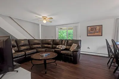 a living room with a brown leather couch and a table at Two Brooks Lodge in Bennington