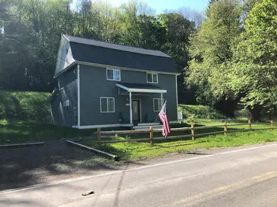 a house on the side of a road with a flag at 1st Class Rentals Cooperstown New 3 Bedroom House in Cooperstown