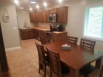 a kitchen with a wooden table and a dining room at 1st Class Rentals Cooperstown New 3 Bedroom House in Cooperstown