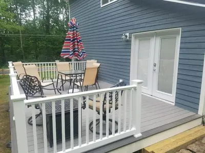 a deck with chairs and a christmas tree on it at 1st Class Rentals Cooperstown New 3 Bedroom House in Cooperstown