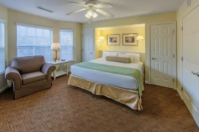 a bedroom with a large bed and a chair at Holiday Inn Club Vacations Oak n Spruce Resort in the Berkshires in South Lee