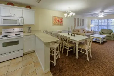 a kitchen and living room with a table and a couch at Holiday Inn Club Vacations Oak n Spruce Resort in the Berkshires in South Lee