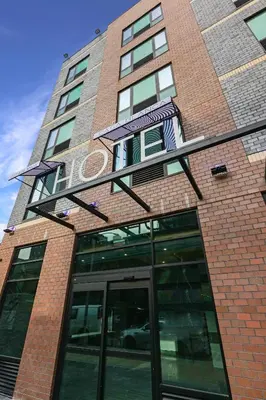 a tall brick building with a revolving door at Casa Blanca Hotel Brooklyn Downtown in Brooklyn