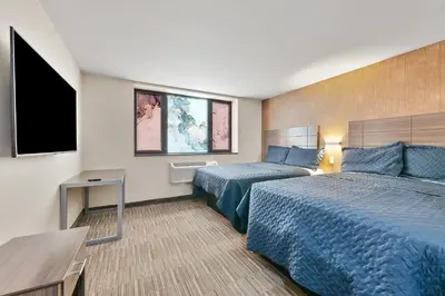 a hotel room with two beds and a flat screen tv at Casa Blanca Hotel Brooklyn Downtown in Brooklyn