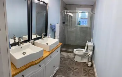 a bathroom with two sinks and a shower and a toilet at 1st Class Rentals The Thurman Munson House in Cooperstown