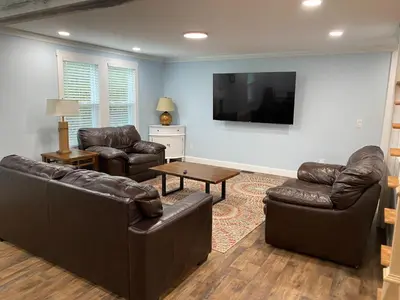 a living room with leather furniture and a flat screen tv at 1st Class Rentals The Thurman Munson House in Cooperstown