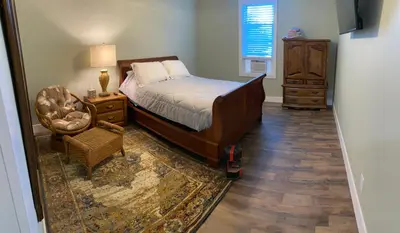 a bedroom with a bed and a chair and a dresser at 1st Class Rentals The Thurman Munson House in Cooperstown