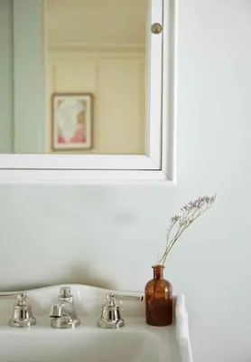 a bathroom sink with a mirror and a vase with flowers at Callicoon Hills in Callicoon Center