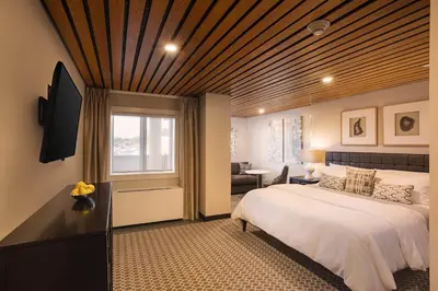 a bedroom with a large bed with a wooden ceiling at Fathoms Hotel & Marina in Port Washington