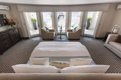 a large bedroom with a large bed and chairs at Fathoms Hotel & Marina in Port Washington