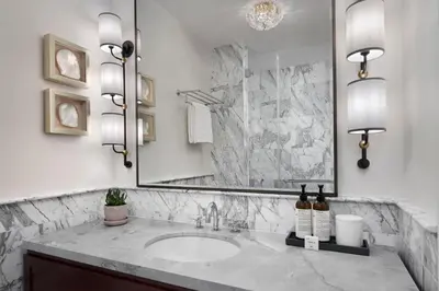 a bathroom with a sink and a large mirror at The Wall Street Hotel New York City in New York