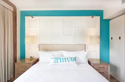 a bedroom with a white bed with a blue wall at Margaritaville Resort Times Square in New York