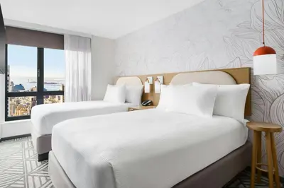 a hotel room with two beds and a window at SpringHill Suites by Marriott New York Manhattan Chelsea in New York