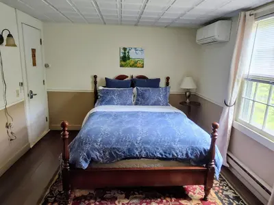a bedroom with a bed with a blue comforter at Doveberry Inn in West Dover