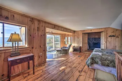 a bedroom with wooden walls and a bed and a fireplace at Full Private Home on 32-Acres with Stellar Views! in North Blenheim