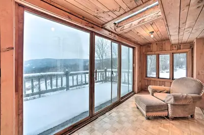 a room with a chair and large windows at Full Private Home on 32-Acres with Stellar Views! in North Blenheim