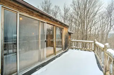 a screened in porch of a house in the snow at Full Private Home on 32-Acres with Stellar Views! in North Blenheim