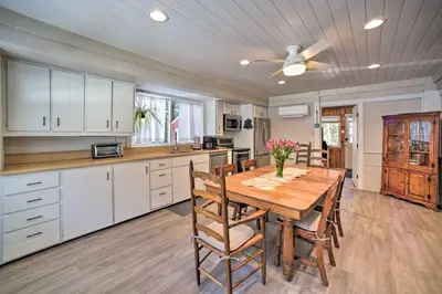 a kitchen and dining room with a wooden table and chairs at Cozy Great Barrington Home about 1 Mi to Ski Resort! in Great Barrington