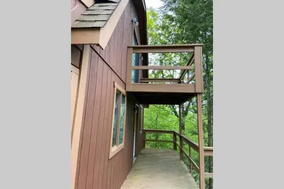 a house with a wooden walkway leading up to a building at Regent Hilltop Cabin in Sandyville