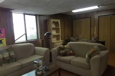 a living room with two couches and a table at Regent Hilltop Cabin in Sandyville