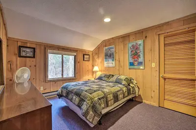 a bedroom with a bed in a room with wooden walls at Cozy Mountain Retreat with Deck about 3 Mi to Mount Snow in West Dover