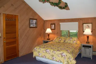 a bedroom with a bed and two lamps on two tables at Cozy Mountain Retreat with Deck about 3 Mi to Mount Snow in West Dover