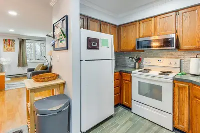 a kitchen with a white refrigerator and wooden cabinets at Primely Located Dover Escape Less Than 1 Mi to Mt Snow! in Dover