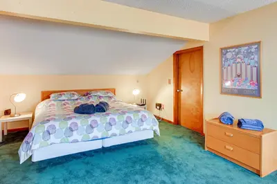 a bedroom with a large bed with blue carpet at Primely Located Dover Escape Less Than 1 Mi to Mt Snow! in Dover