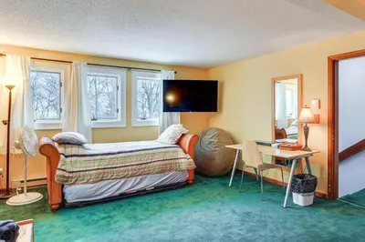 a bedroom with a bed and a desk and windows at Primely Located Dover Escape Less Than 1 Mi to Mt Snow! in Dover