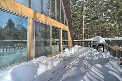 a house with a pile of snow in front of it at Cozy A-Frame Cabin with Pool Table 8 Mi to Mt Snow! in Wilmington