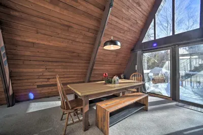 a wooden dining room with a wooden table and chairs at Cozy A-Frame Cabin with Pool Table 8 Mi to Mt Snow! in Wilmington
