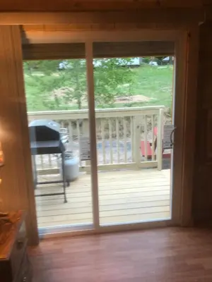a sliding glass door to a deck with a piano at The HideAway Tiny Cabin in East Durham