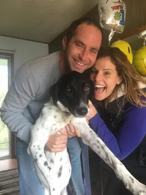a man and a woman holding a black and white dog at The HideAway Tiny Cabin in East Durham