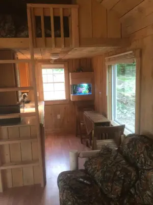 a living room with a couch and a table at The HideAway Tiny Cabin in East Durham