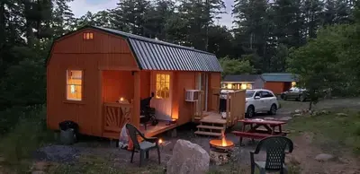 a tiny house in a yard with a table and chairs at The HideAway Tiny Cabin in East Durham