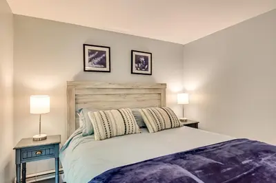 a bedroom with a large bed with two lamps at Lakefront Granby Escape with Private Dock and Kayaks! in Granby