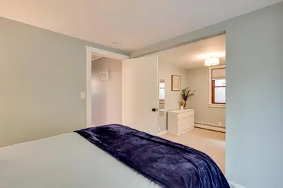 a bedroom with a bed with a blue blanket on it at Lakefront Granby Escape with Private Dock and Kayaks! in Granby