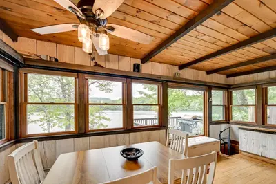 a dining room with a table and chairs and windows at Lakefront Granby Escape with Private Dock and Kayaks! in Granby
