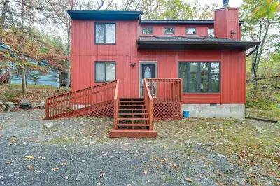 a red house with a staircase in front of it at Fire Pit and Gas Grill Charming Poconos Abode! in Bushkill
