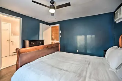 a bedroom with a bed with a blue wall at Hot Tub Secluded Hideaway on Sleepy Hollow Lake in Athens
