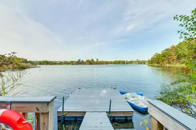 a dock with a boat on a lake at Hot Tub Secluded Hideaway on Sleepy Hollow Lake in Athens