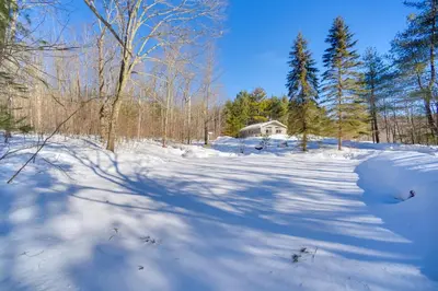 a snow covered field with a house in the background at Private 7-Acre Retreat On-Site Pond, Streams in Jewett