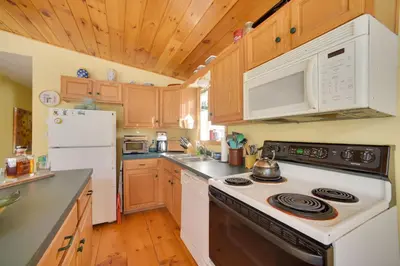 a kitchen with a stove and a white refrigerator at Private 7-Acre Retreat On-Site Pond, Streams in Jewett