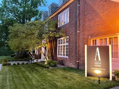 a sign in front of a brick building at The Argus Hotel & Cocktail Lounge in Albany