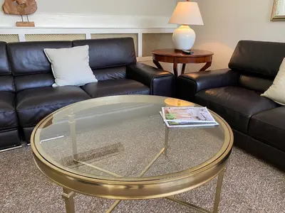 a living room with a couch and a glass table at The Argus Hotel & Cocktail Lounge in Albany