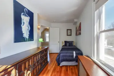 a bedroom with a bed and a large window at Belltown Retreat in Stamford